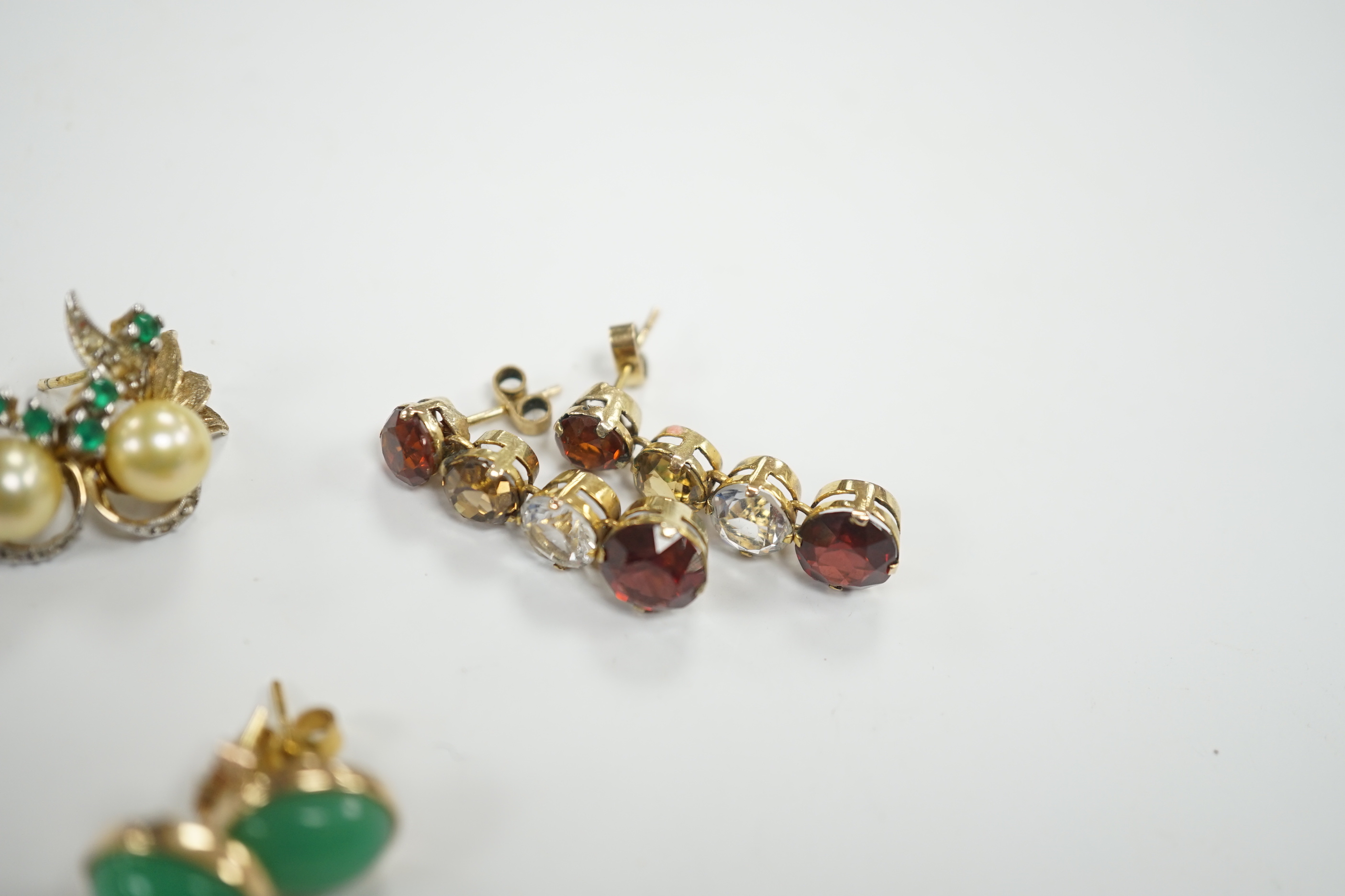 A pair of 1950’s emerald and cultured pearl cluster set earrings, 17mm, a pair of yellow metal and four stone drop earrings and a pair of cabochon chrysoprase ear studs, gross weight 10.3 grams.